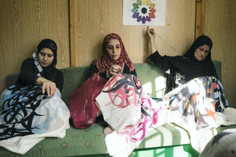 Female Palestinian artisans from Lebanon's Ain Al Heweh refugee camp sew eL Seed's works using tatreez techniques
