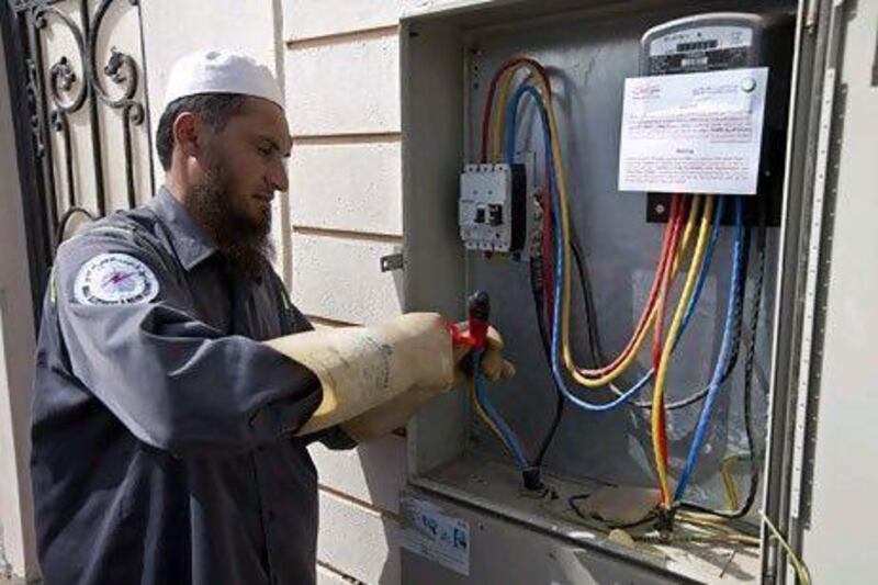 A Dewa employee tapes the main power cable that has been disconnected at a villa in Jafliya earlier this year. Dubai has decided to freeze power and water prices for a few years. Jeff Topping / The National