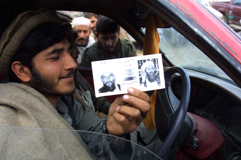 An Afghan soldier displays one of thousands of leaflets dropped by US military planes in December 2001, informing Afghans about the $25 million reward for information leading to the capture of bin Laden and Al Zawahiri. Getty