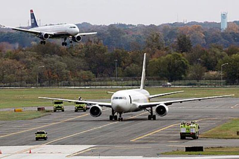 A jet lands near a United Parcel Service jet that is seen isolated on a runway at Philadelphia International Airport.