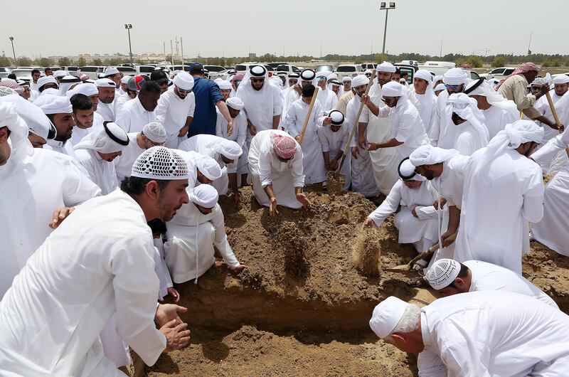 Funeral-goers pay their respects at the burial of Khaled Qai in Al Qusais Cemetery in Dubai. Pawan Singh / The National 