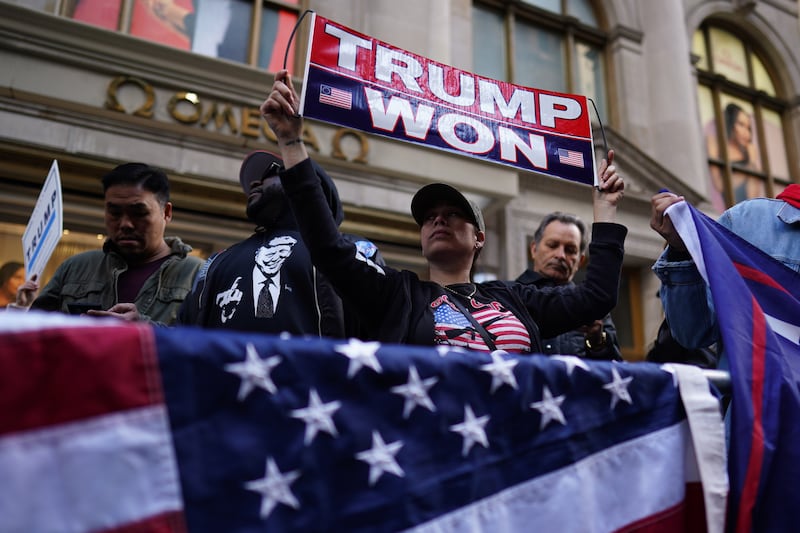 Supporters of Mr Trump stand near Trump Tower in New York, New York. EPA