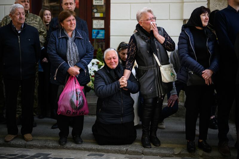 Galina Malets falls to her knees before the funeral service for her brother, fallen soldier Igor Malets, 59, in Lviv. Getty 