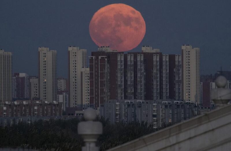 The moon rises from behind apartment buildings in Beijing, China on Monday, November 14, 2016. Ng Han Guan / AP Photo