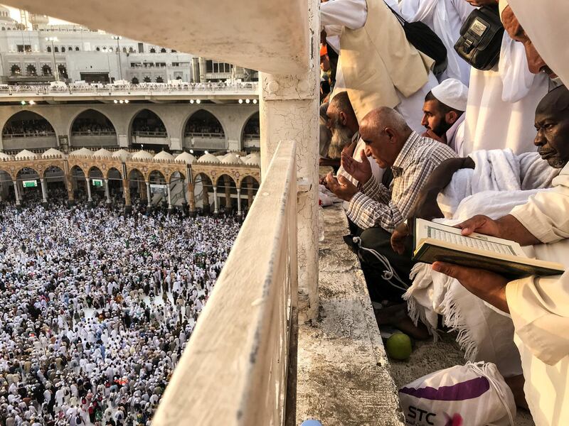 Pilgrims watch as others circle the Kaaba. Reuters