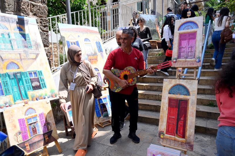 Paintings are on display at an open-air gallery on the St.  Nicolas stairs during the 'Gemmayze Street Festival' under the slogan 'Gemmayze to walk and on the balcony' (Gemmayzeh 3al mashi w 3al balcon) in Beirut, Lebanon, 13 May 2023.  Thousands of Lebanese and foreign visitors flocked to Beirut's famous Gemmayze Street Festival which includes a street market, live music, an art fair, food and bar lounges.  The Gemmayze Street Festival runs from 13 to 14 May 2023.   EPA / WAEL HAMZEH