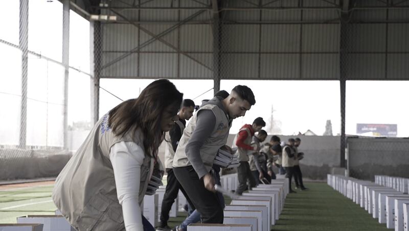 Volunteers in Lebanon collect packaged meals from a warehouse.