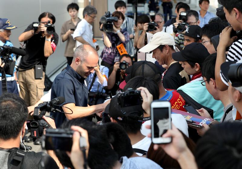 Iniesta signs his autograph for Japanese fans upon his arrival at Kansai International Airport. Jiji Press / EPA