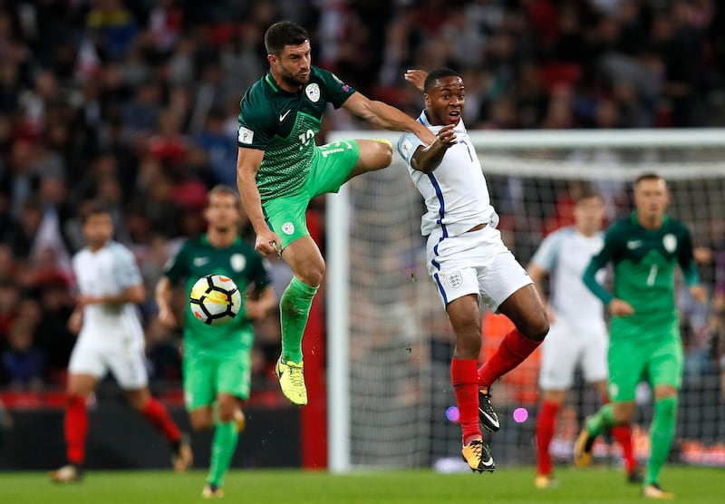 England's Raheem Sterling jumps for the ball with Slovenia's Bojan Jokic. Kirsty Wigglesworth / AP Photo