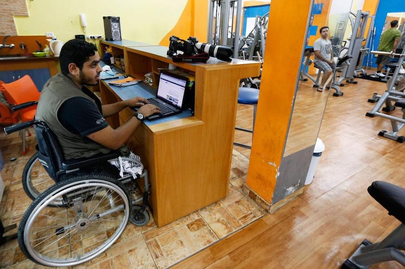 Freelance photographer Moamen Qreiqea uses a laptop computer at a gym.