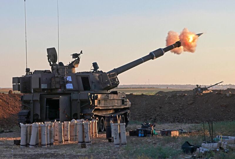 Israeli soldiers fire a 155mm self-propelled howitzer towards the Gaza Strip from their position along the border. AFP