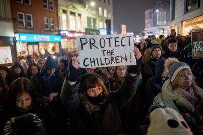 Protesters hold placards to demand action after it emerged that refugee children had gone missing. Photo: EPA
