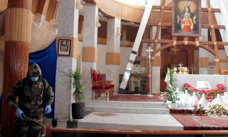 A member of the civil defense team disinfects inside Our Lady of Salvation church to prevent the spread of the coronavirus disease (COVID-19), in Baghdad, Iraq December 30, 2020. REUTERS/Thaier Al-Sudani