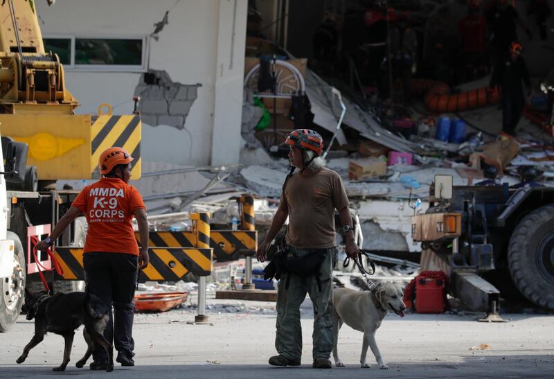 epa07522102 Emergency responders with K-9 dogs join search operations at a collapsed commercial building in Porac town, Pampanga Province, north of Manila, Philippines, 23 April 2019. A 6.1-magnitude earthquake occurred on 22 April in the Philippine region of Luzon with an epicenter located northeast of Zambales province, according to data from the Philippine Institute of Volcanology and Seismology (Phivolcs). According to latest data from the National Disaster Risk Reduction and Management Council (NDRRMC), at least seven people were killed, 81 were hurt and 24 are still missing.  EPA/FRANCIS R. MALASIG