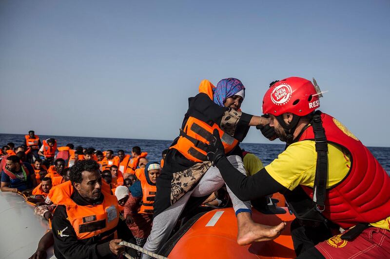 A migrant aboard a rubber dinghy off the Libyan coast is helped by rescuers aboard the Open Arms aid boat, of Proactiva Open Arms Spanish NGO, Saturday, June 30, 2018. 60 migrants were rescued as Italy's right-wing Interior Minister Matteo Salvini tweeted: "They can forget about arriving in an Italian port." (AP Photo/Olmo Calvo)