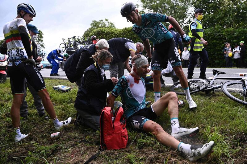 Team B&B KTM's Cyril Lemoine is helped by medical staff after crashing during the first stage of the Tour de France.