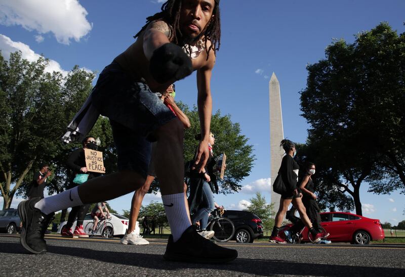 Protesters march past the Washington Monument  in Washington DC. Reuters