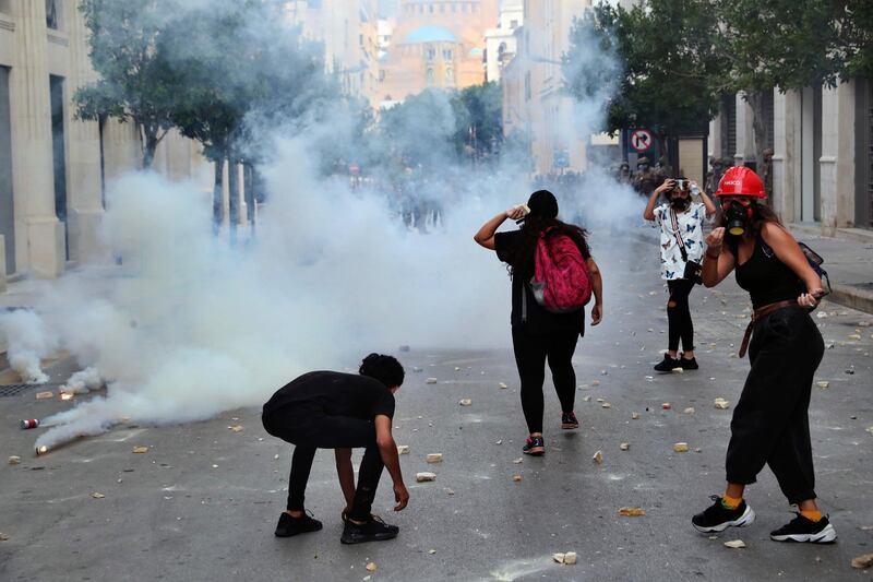 Anti-government protesters throw stones towards police near Parliament Square. AP