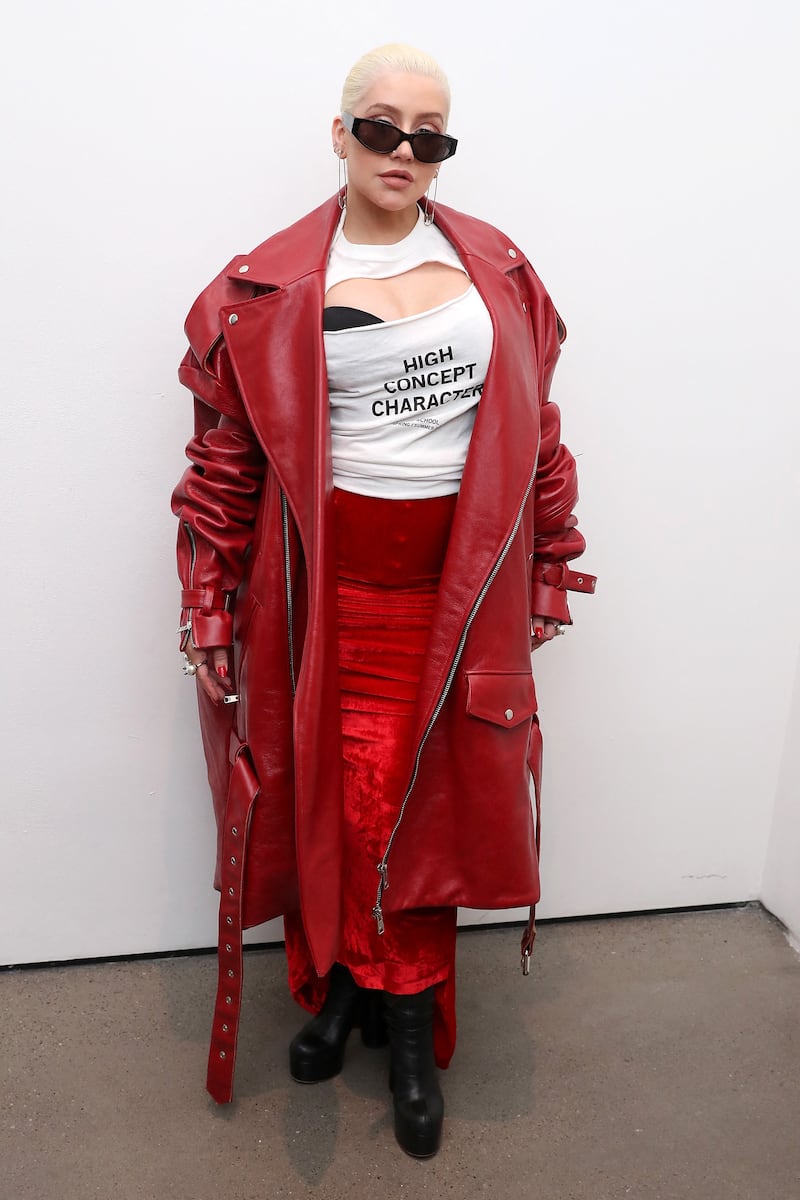 Christina Aguilera, wearing a red leather coat over a skirt and top, poses backstage at the Christian Cowan Show during New York Fashion Week on September 8, 2018. AFP