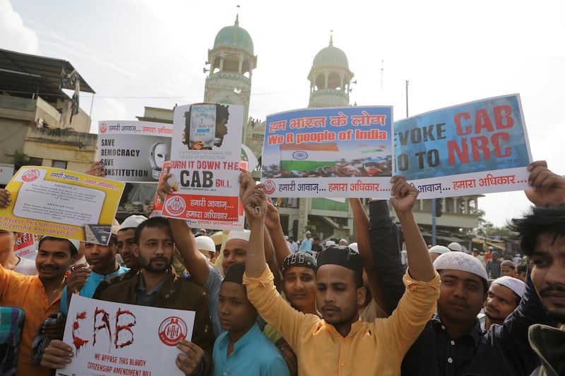 Indian Muslims hold placards during a protest against Citizenship Amendment Bill after Friday prayers in Ahmadabad, India, Friday, Dec. 13, 2019.  Japanese Prime Minister Shinzo Abe is postponing a meeting with Prime Minister Narendra Modi in India's northeast. The region has been the site of continuing protests against a new law that grants citizenship to non-Muslims who migrated from neighboring countries. (AP Photo/Ajit Solanki)