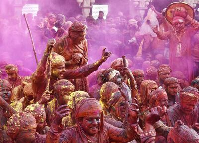 NANDGAON, INDIA - MARCH 7: Indian villagers smear themselves with colours during the Lathmar Holi festival at the Nandji Temple on March 7, 2017 in Nandgaon near Mathura, India. The women of Nandgaon, the hometown of Hindu God Krishna, attack the men from Barsana, the legendary hometown of Radha, consort of Hindu God Krishna, with wooden sticks in response to their efforts to put color on them, reciprocating acts performed yesterday in Barsana between the women of that village with the men of Nandgaon as they observe the Lathmar Holi festival. (Photo by Ajay Aggarwal/Hindustan Times via Getty Images)