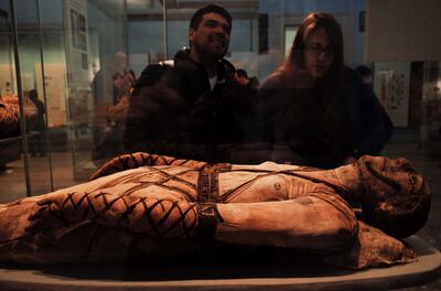Visitors admire an ancient Egyptian mummy at the British Museum. Getty Images