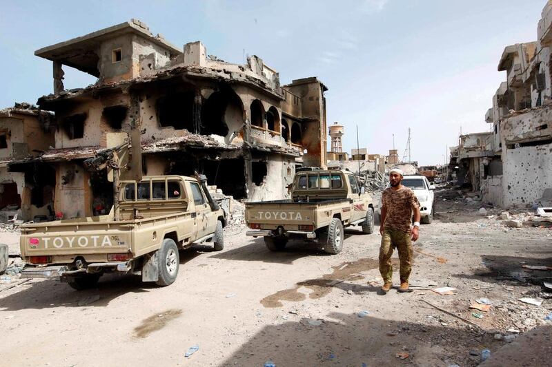 A fighter of Libyan forces allied with the UN-backed government walks past a ruined house in Cambo area which they captured from ISIL militants on October 16, 2016, in Sirte, Libya. Ismail Zitouny/Reuters