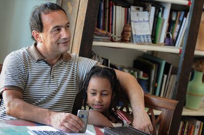 (FILES) In this file photo taken on June 22, 2011, Riace mayor, Domenico Lucano poses in his office with a young girl from Ethiopia.  The Prosecutor's Office of Locri in Calabria announced on October 2, 2018 the arrest of Lucano, the mayor of Riace, a small village that has been hosting migrants and asylum seekers for years, on the grounds of suspected aid to illegal immigration. / AFP / MARIO LAPORTA
