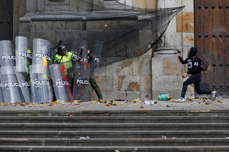 A demonstrator throws a stone at riot police during a protest in Bogota, Colombia. Reuters