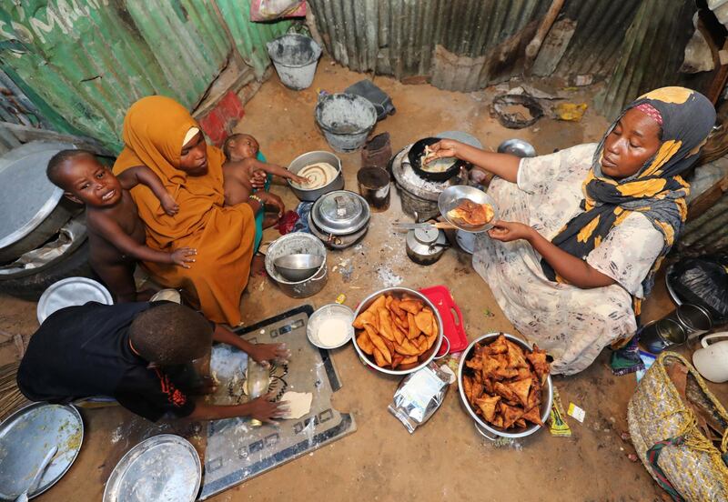 An internally displaced Somali woman and her children prepare their Iftar meal during the month of Ramadan in Mogadishu, Somalia. Reuters