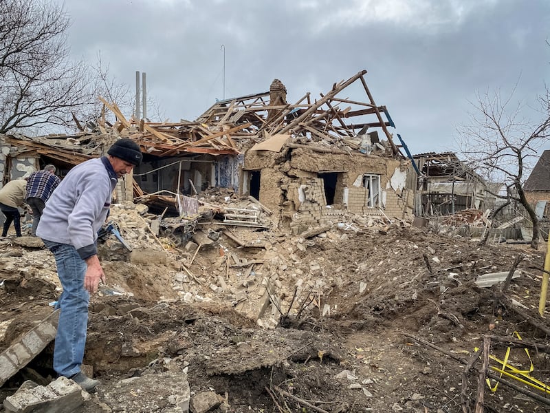 Residents inspect a crater left by a Russian military strike in the village of Komyshuvakha in the Zaporizhzhia region. Reuters