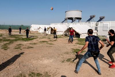Syrian refugees play football inside the Temporary Accommodation Centre in Kokkinotrimithia, some 20 kilometres outside the Cypriot capital Nicosia on November 5, 2019. - Cyprus police said they towed to shore 131 migrants, almost all from Syria, after they were sighted on an overcrowded boat off the Mediterranean island’s northwest tip. The boat with 129 Syrians, one Lebanese and an Egyptian on board was located five nautical miles off the coast by a patrol vessel and tugged to Latchi harbour. (Photo by Iakovos Hatzistavrou / AFP)