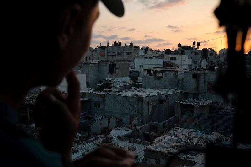 In this Sept. 12, 2018, photo, a boy looks out of the window as the sun sets in Gaza City. Ever since Hamas launched demonstrations in March against Israel's blockade of Gaza, children have been a constant presence in the crowds. Since then, U.N. figures show that 948 children under 18 have been shot by Israeli forces and 2,295 have been hospitalized, including 17 who have had a limb amputated. (AP Photo/Felipe Dana)