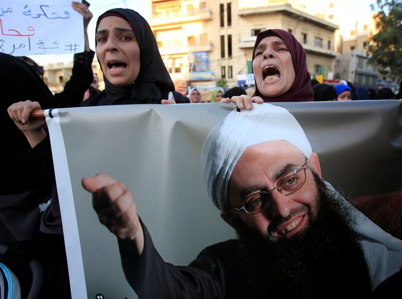 Supporters of detained Lebanese hardline Sunni Islamist cleric Ahmad al-Assir carry his picture as they protest after a Lebanese military court sentenced him to death by execution, in Sidon, southern Lebanon September 28, 2017. REUTERS/Ali Hashisho