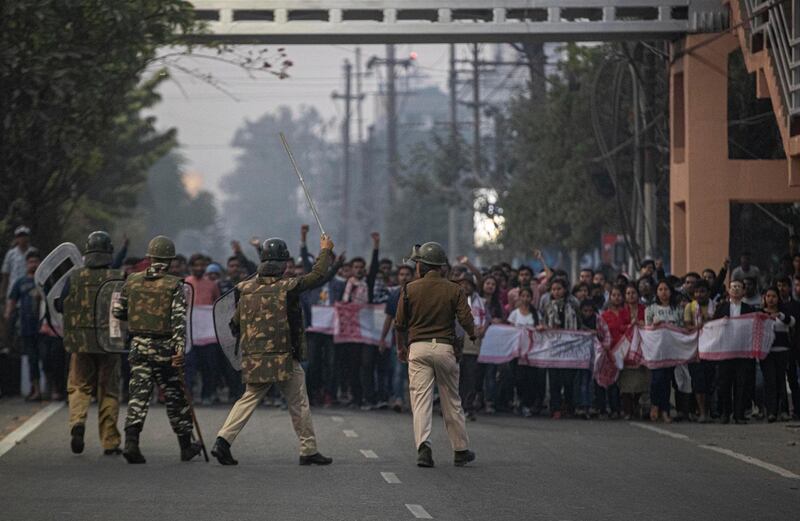Indian police and paramilitary personnel stop protesters during a curfew in Gauhati, India, Thursday, Dec. 12, 2019. Police arrested dozens of people and enforced a curfew Thursday in several districts in Indiaâ€™s northeastern Assam state where thousands protested legislation that would grant citizenship to non-Muslims who migrated from neighboring countries. (AP Photo/Anupam Nath)