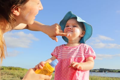Mother putting sun cream on toddler girl. Getty Images