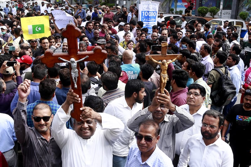 Members of Pakistan's Christian community hold up crosses during a protest in Karachi after armed mobs in Jaranwala attacked two churches and private homes. EPA 