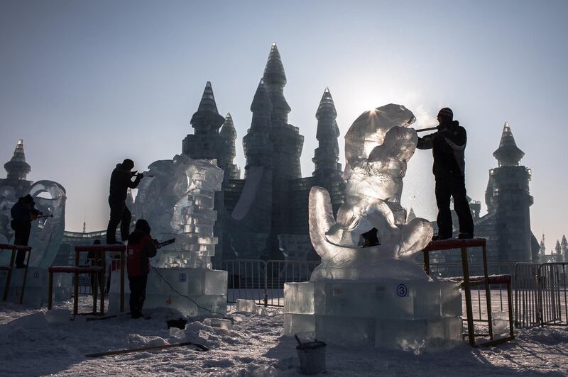 Participants carve their ice sculptures. EPA