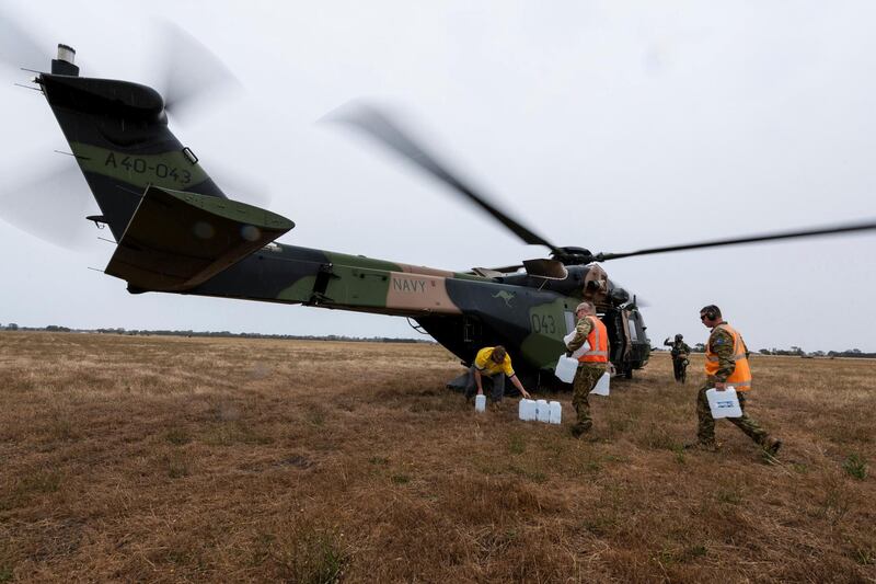 A Royal Australian Navy helicopter is loaded with supplies at Bairnsdale for the fire impacted community of Cann River. AP