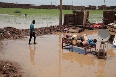 A Sudanese man walks amid the ruins of his home destroyed by floods in the village of Aboud in the El Manaqil district of Al Jazeerah State south of the capital Khartoum. AP 