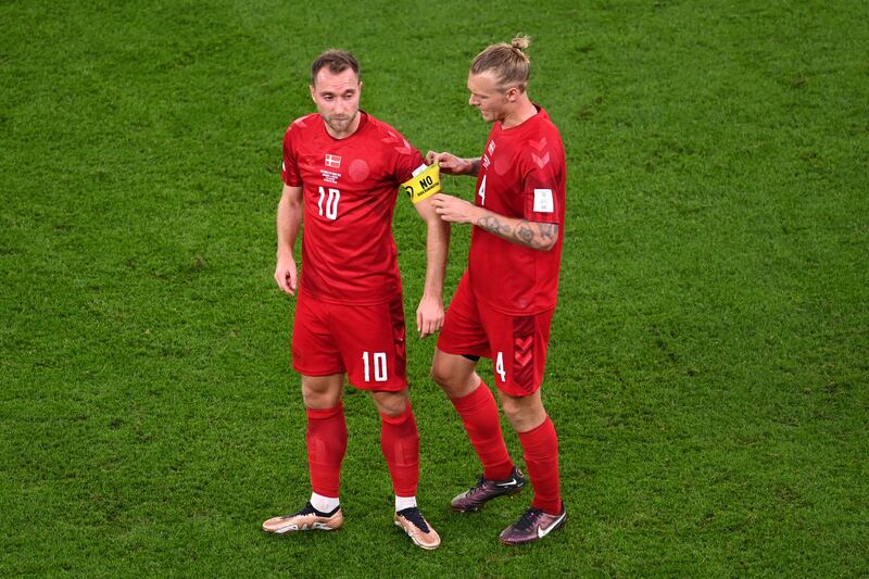 Denmark's Simon Kjaer hands the captain's armband to Christian Eriksen. Getty