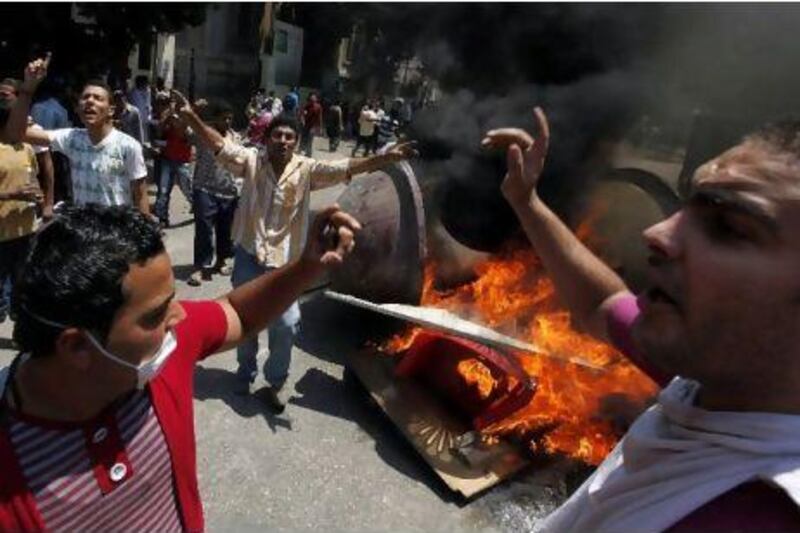 Demonstrators chant after burning a police booth in front of the interior ministry in Cairo yesterday.
