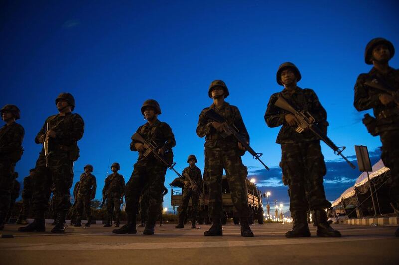 Thai army soldiers stand guard at the main entrance of the pro-government ‘Red Shirts’ rally site after they shut it down and cleared protesters from the site, after Thailand’s army chief announced that the armed forces were seizing power, on the outskirts of Bangkok. Nicolas Asfouri / AFP Photo