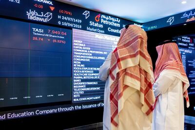 Visitors look at stock price information displayed on a digital screen inside the Saudi Stock Exchange, also known as the Tadawul, in Riyadh, Saudi Arabia, on Tuesday, April 10, 2018. Foreign investors bought more Saudi stocks in March than ever before in anticipation of the kingdom���s upgrade to emerging-market status. Photographer: Abdulrahman Abdullah/Bloomberg