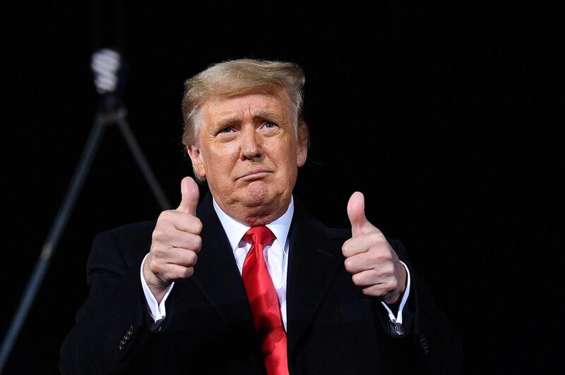 US President Donald Trump gives two thumbs up during a rally in support of Republican incumbent senators Kelly Loeffler and David Perdue ahead of Senate runoff in Dalton, Georgia on January 4, 2021. - President Donald Trump, still seeking ways to reverse his election defeat, and President-elect Joe Biden converge on Georgia on Monday for dueling rallies on the eve of runoff votes that will decide control of the US Senate. Trump, a day after the release of a bombshell recording in which he pressures Georgia officials to overturn his November 3 election loss in the southern state, is to hold a rally in the northwest city of Dalton in support of Republican incumbent senators Kelly Loeffler and David Perdue. (Photo by MANDEL NGAN / AFP)