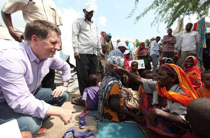 FILE PHOTO: Justin Forsyth (L), Chief Executive of Save the Children UK, talks to internally displaced Somalis at a camp in the Hodan district of Somalia's capital Mogadishu, November 21, 2012. REUTERS/Feisal Omar/File Photo