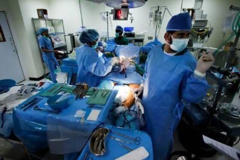Dr Saud Taymoor (wearing dark glasses) performs the first coronary artery bypass surgery on a male patient at Al Qassimi Hospital in Sharjah in May. Sarah Dea / The National