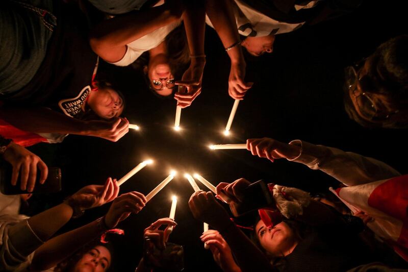 Lebanese protesters light up candles during a vigil at a demonstration in the southern Lebanese city of Sidon on the tenth day of country-wide protests against tax increases and official corruption.  AFP