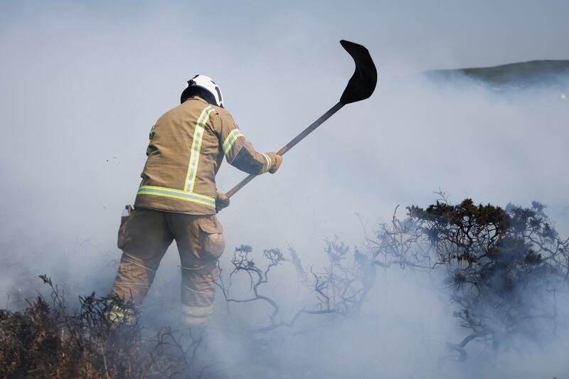 A firefighter attends a gorse bush fire during a heatwave near Zennor, Cornwall. Reuters