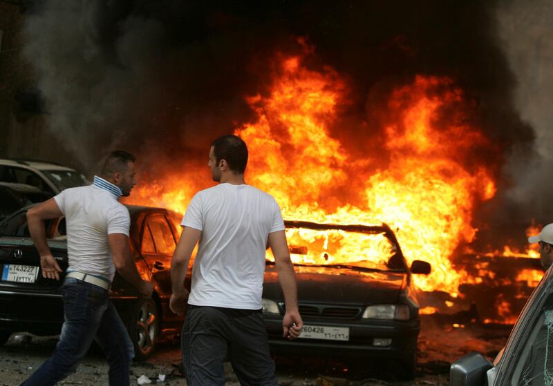 Men are seen near burning cars at the site of an explosion in Beirut's southern suburbs July 9, 2013. Several people were killed or wounded when a car bomb hit Beirut's southern suburbs on Tuesday, a stronghold for the Lebanese Shi'ite Hezbollah militant group that has been fighting in Syria's civil war, medics said. REUTERS/Issam Kobeisi  (LEBANON - Tags: POLITICS CIVIL UNREST) *** Local Caption ***  LBN05_LEBANON-EXPLO_0709_11.JPG